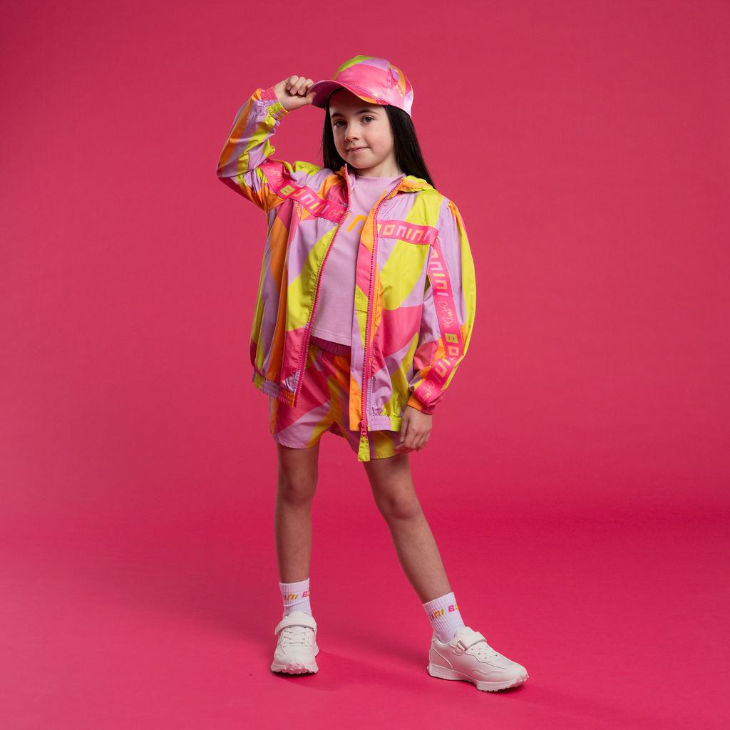 Young girl wearing a colorful Bonini outfit with a pink background