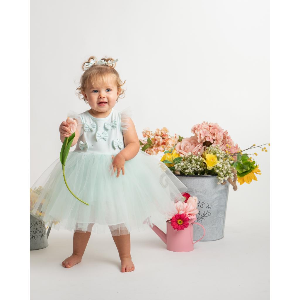 Model wearing a Caramelo mint tulle dress with bow‑detail bodice and layered skirt. A soft, elegant occasion dress for baby girls