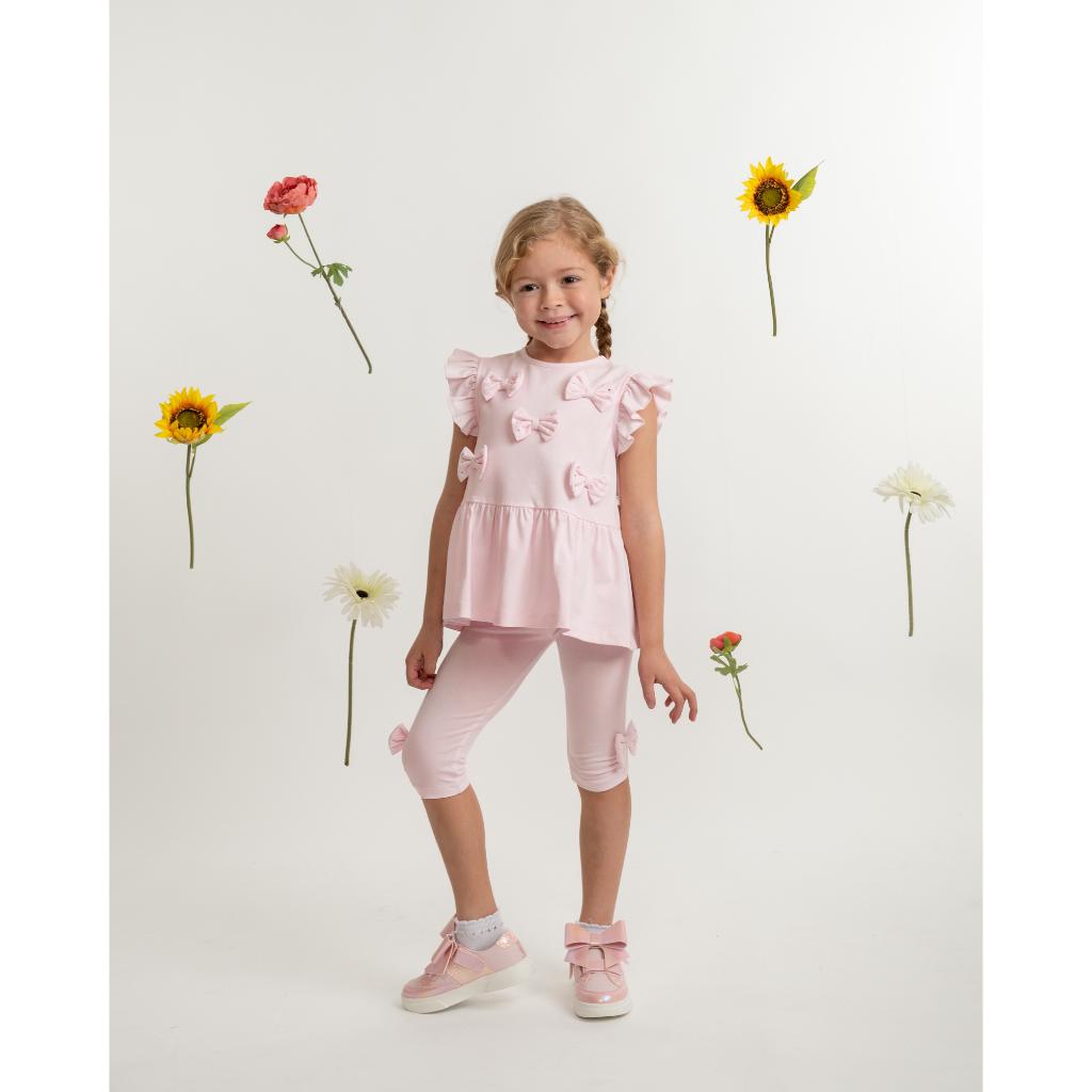 Model wearing a Caramelo pink bow legging set for girls. Soft, stylish and perfect for everyday wear, parties and summer outings. 