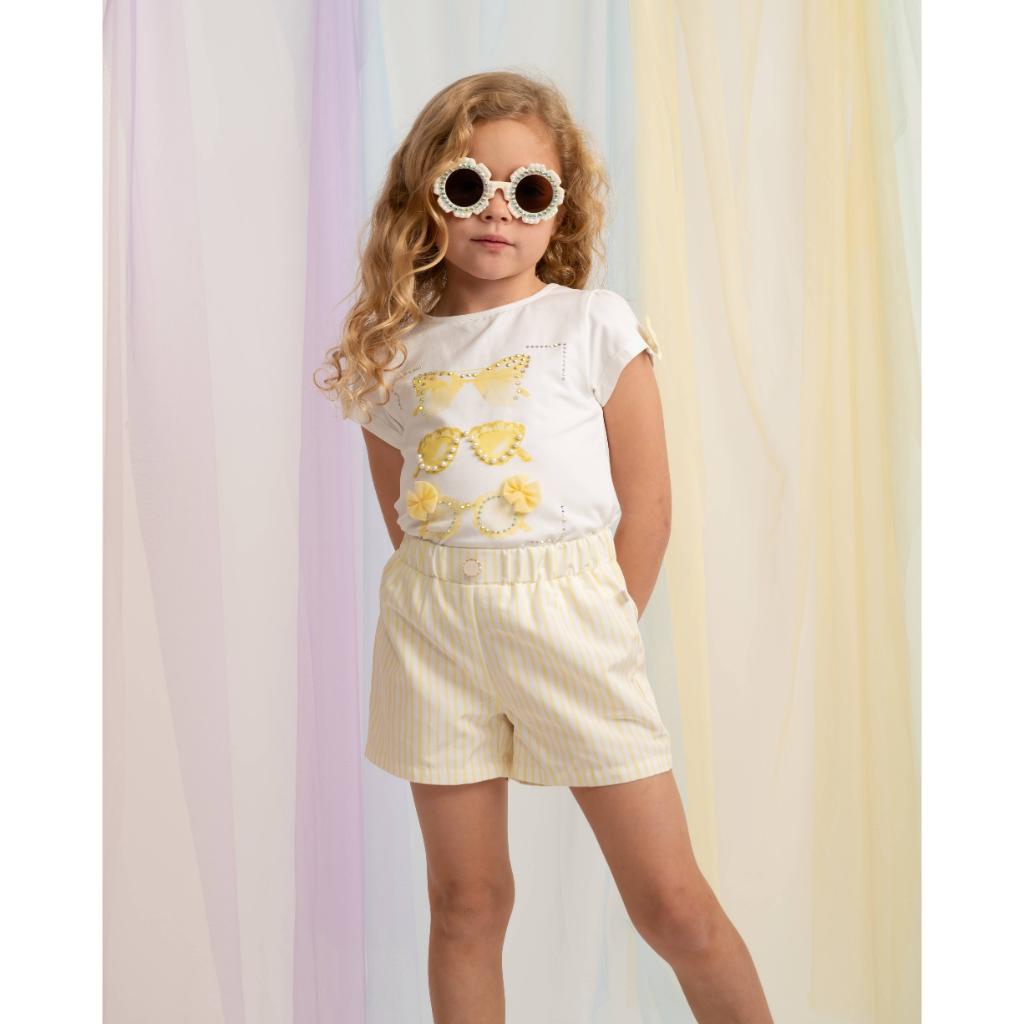 Model wearing a Caramelo sunglasses T‑shirt and striped shorts set for girls, complete with free matching sunglasses. A bright, fun and stylish summer outfit