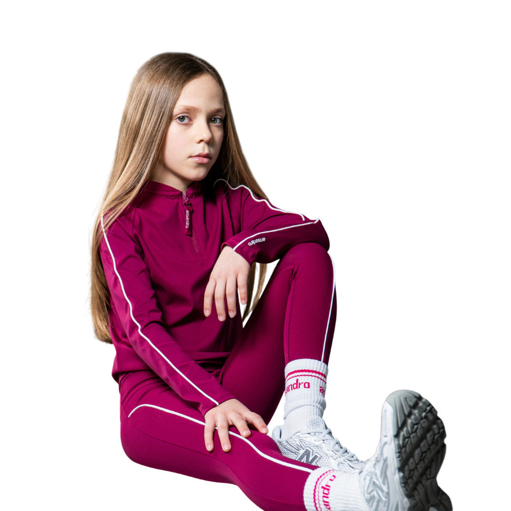 Girl wearing a magenta Ansandro tracksuit with white accents on a white background